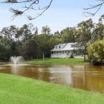 Front view of grounds of NORA House and body of water