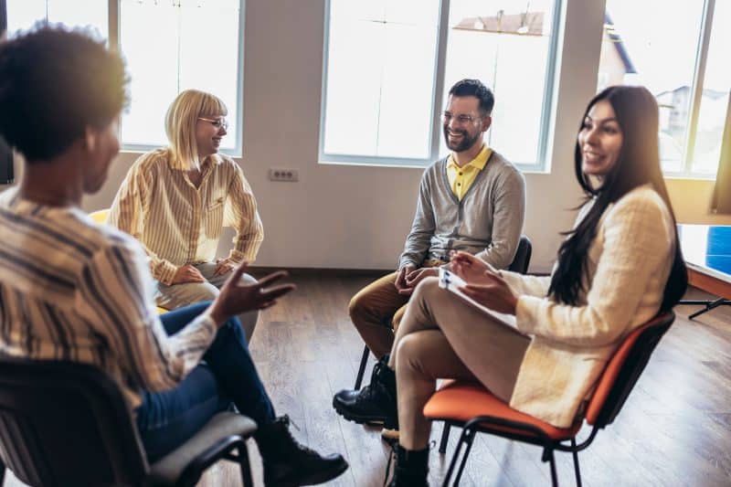 Support group patients in a group session talking about addiction treatment for a loved one
