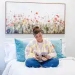 Woman sitting on a bed at Eating Disorder Treatment Centers of Louisiana reading.