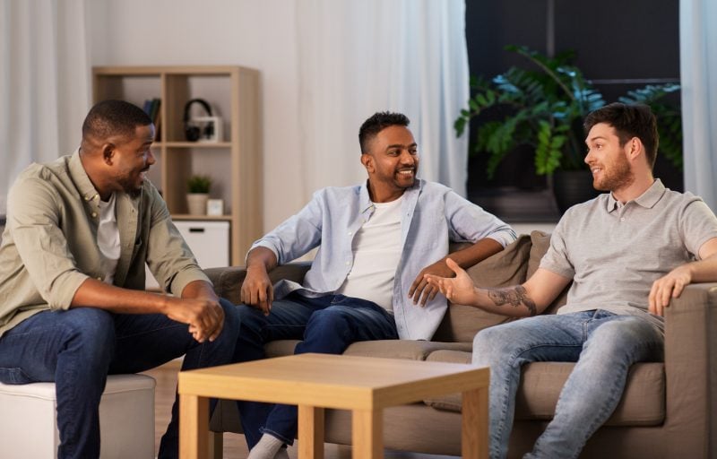 Men sitting talking together in a sober living home.