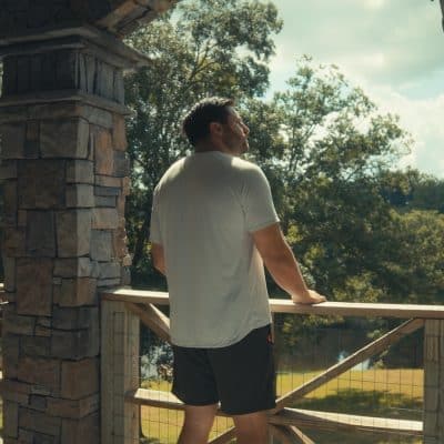 Man looking out across the campus of a Birmingham Sober Living Home near Tuscaloosa Recover Now Central Alabama House.