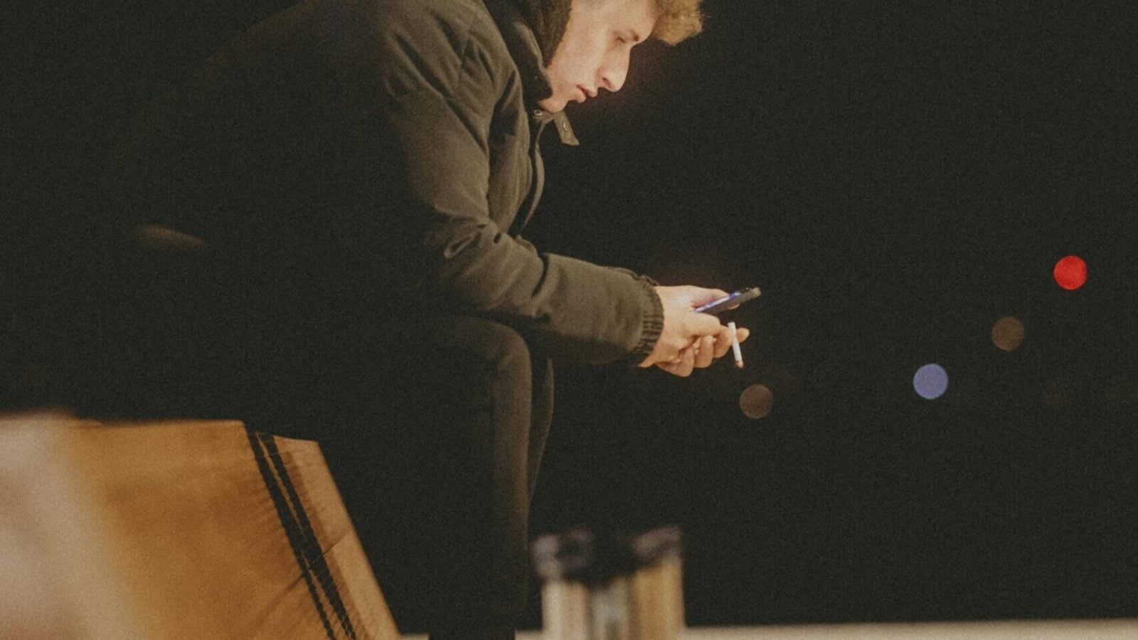 A person sitting alone on a chair in a dimly lit room