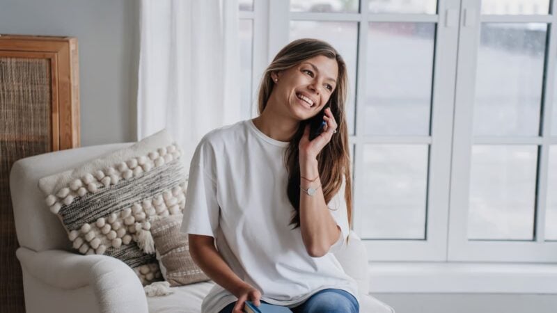 young woman on the phone with recover now admissions team to find out how much rehab costs